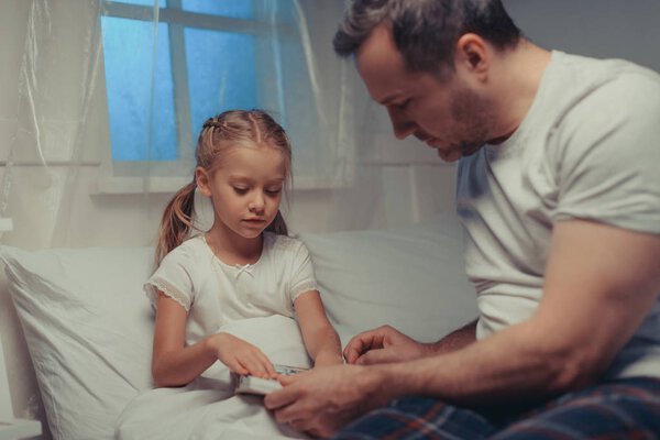 family reading book at bedtime