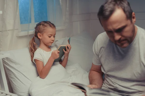 Familj läsa böcker vid sänggåendet — Stockfoto