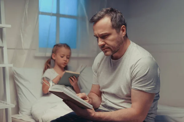 Family reading books at bedtime — Stock Photo, Image