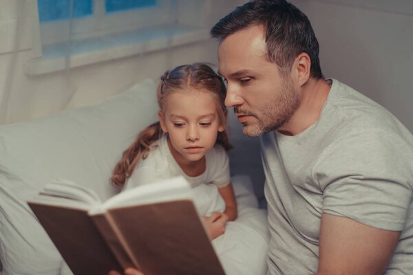 family reading book at bedtime