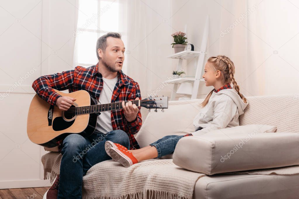 father and daughter playing guitar