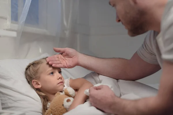 Father touching forehead of sick daughter — Stock Photo, Image