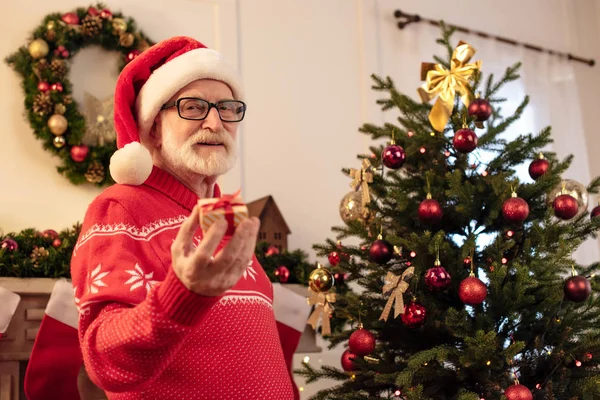 Senior man met klein geschenk met Kerstmis — Stockfoto