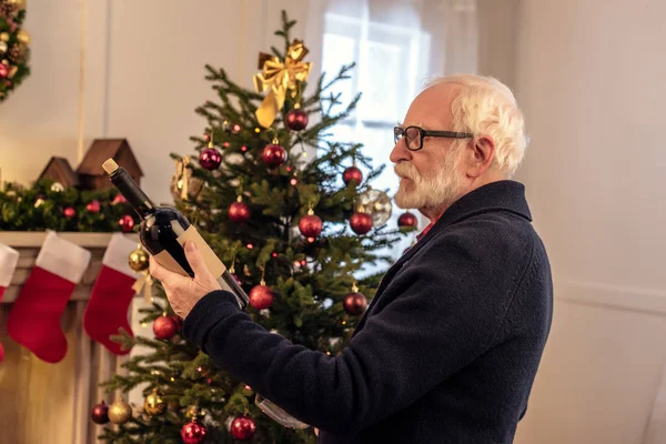 Starszy człowiek z winem w okresie Bożego Narodzenia — Darmowe zdjęcie stockowe