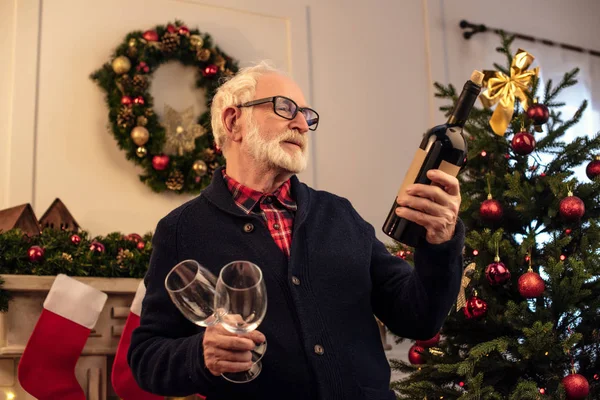 Senior man met wijn bij christmastime — Stockfoto