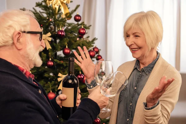 Senior couple with wine at christmas — Free Stock Photo