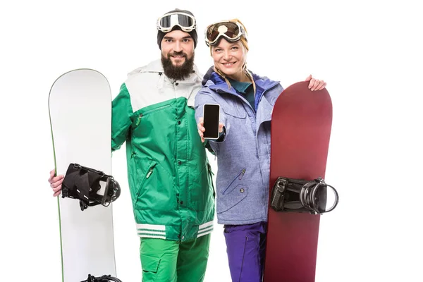 Pareja con tablas de snowboard mostrando smartphone — Foto de Stock