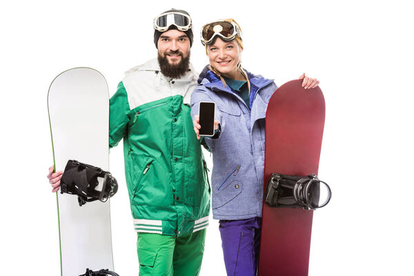 couple with snowboards showing smartphone