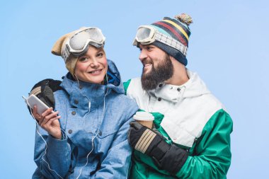 young couple in snowboarding clothing clipart