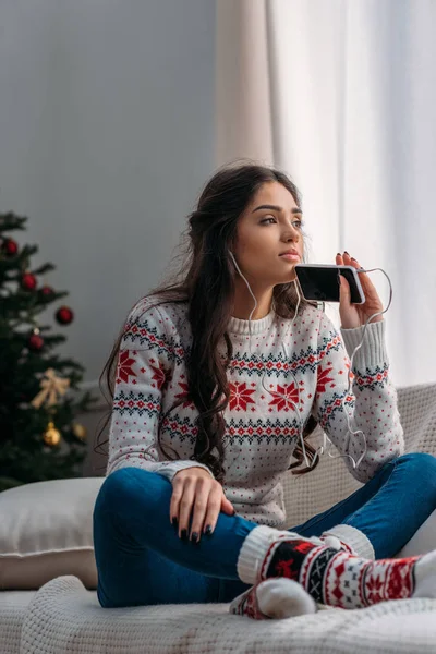 Femme écouter de la musique dans les écouteurs sur Noël — Photo