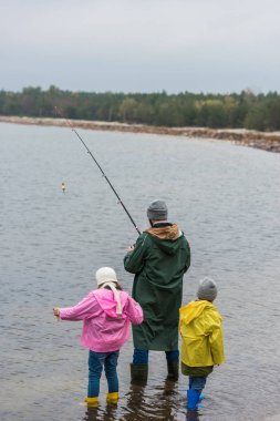 father and kids fishing together clipart