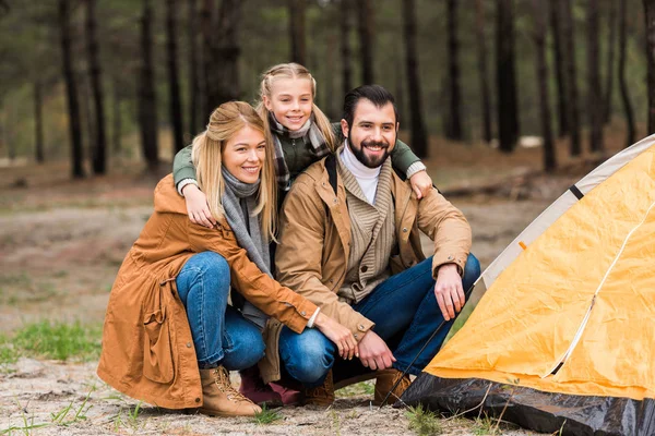 Молодая семья устанавливает палатку — стоковое фото
