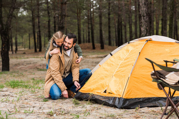 father and daughter installing tent