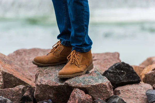 Man in stylish shoes standing on rocks — Stock Photo, Image