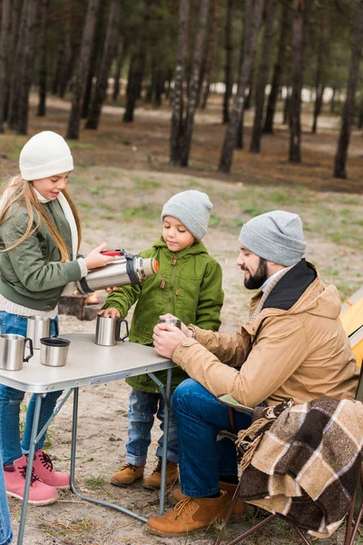 Padre e hijos con bebidas calientes al aire libre — Foto de stock gratis