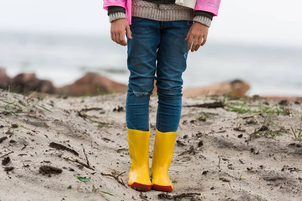 Kind in regenjas en rubber laarzen — Stockfoto