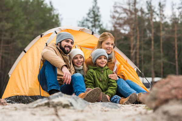 family sitting near tent