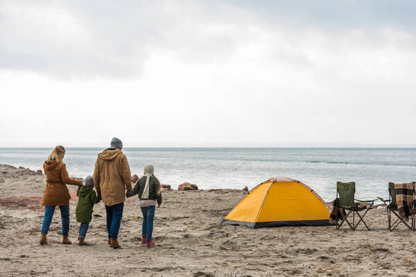 family walking to tent on seashore