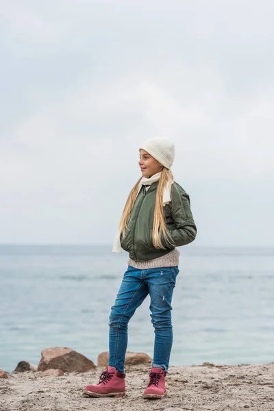 Girl standing alone on seashore — Free Stock Photo