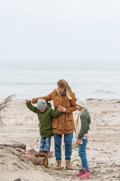 mother and kids on seashore