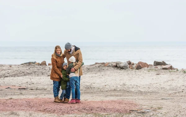 Family emracing on seashore — Stock Photo, Image