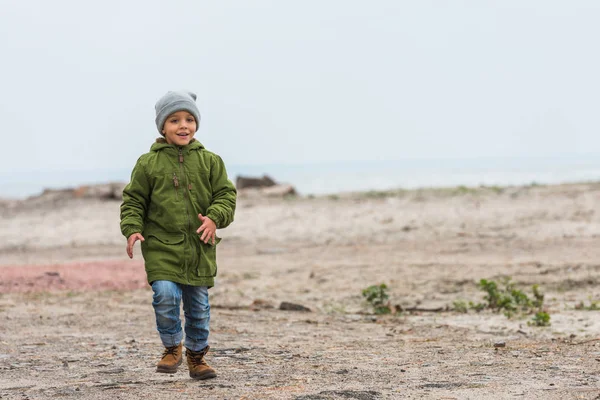 Jongen uitgevoerd door seashore — Gratis stockfoto