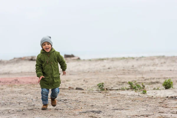 Junge läuft am Strand entlang — Stockfoto