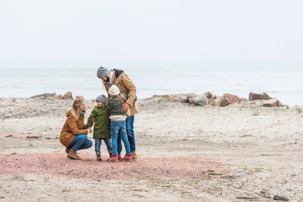 Family emracing on seashore — Stock Photo, Image