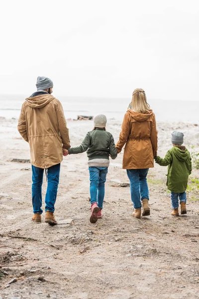 Familia caminando por la orilla del mar — Foto de Stock