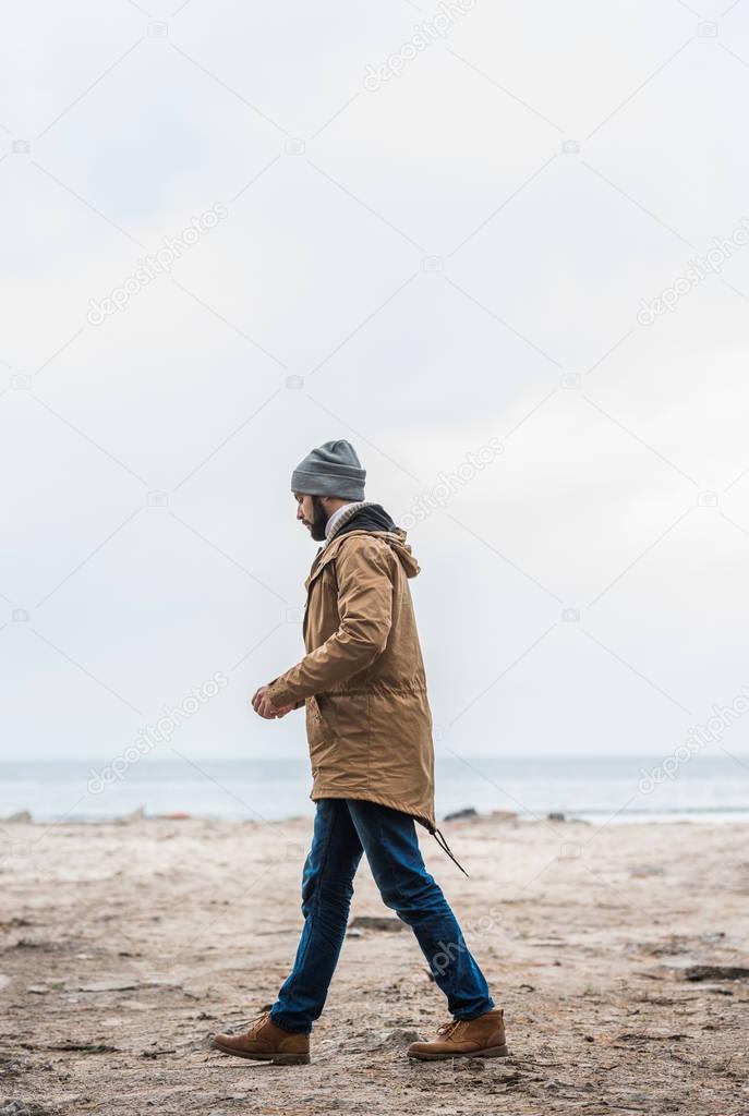 lonely man walking by seashore