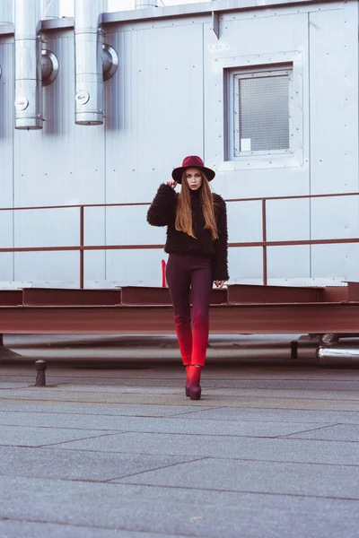 Woman in autumn outfit standing on roof — Stock Photo, Image