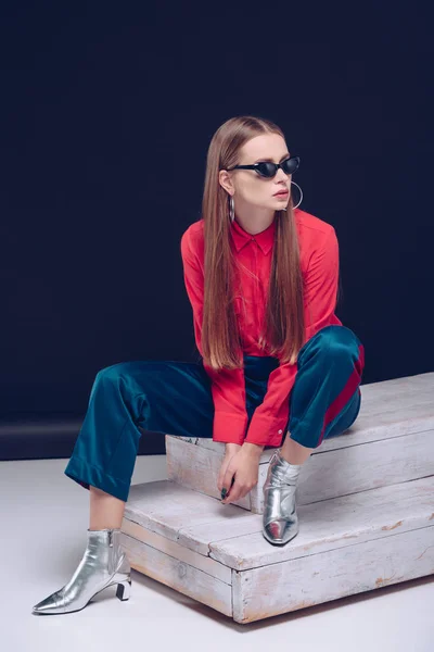 Vrouw in rood shirt zittend op de trap — Stockfoto