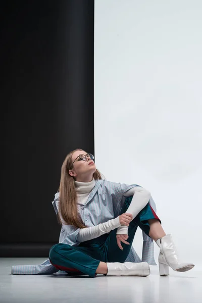 Woman in stylish outfit sitting on floor — Stock Photo, Image