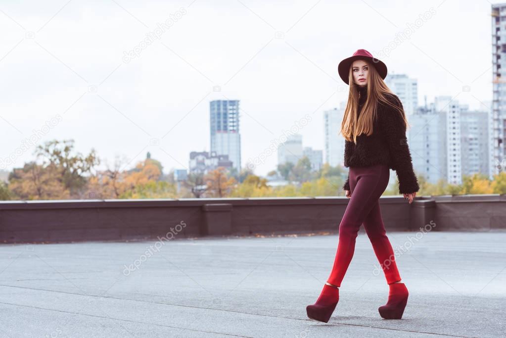 woman in stylish outfit walking on roof