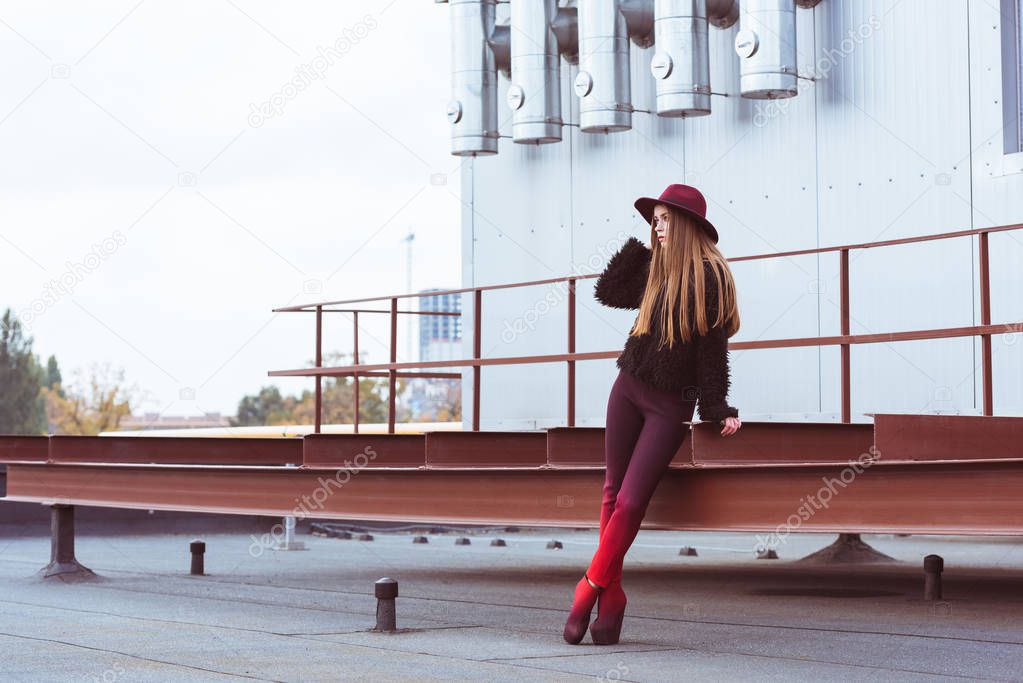woman in autumn outfit standing on roof