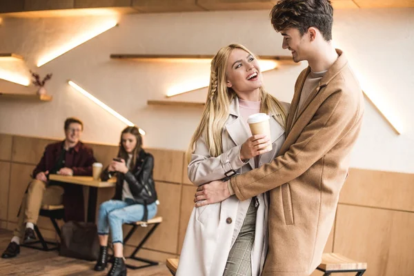 Boyfriend hugging girlfriend in cafe — Stock Photo, Image