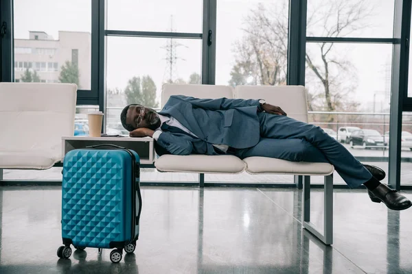 Geschäftsmann schläft auf Stühlen am Flughafen — Stockfoto