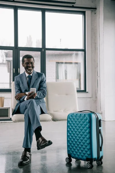 Sonriente hombre de negocios esperando en el aeropuerto — Foto de Stock