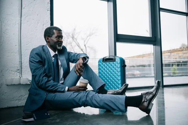 Бізнесмен сидить на підлозі в аеропорту — стокове фото