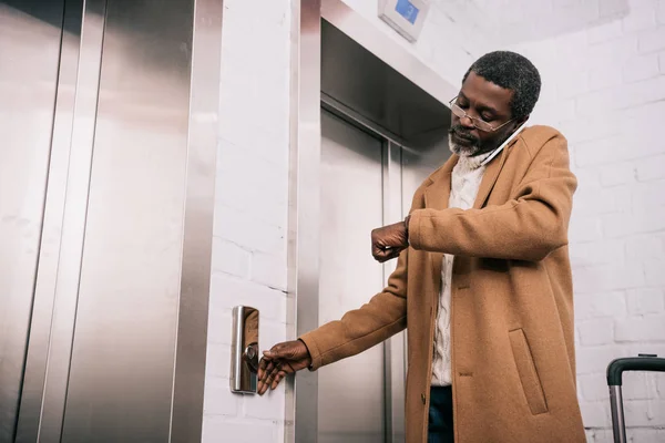 Hombre de mediana edad llamando ascensor —  Fotos de Stock