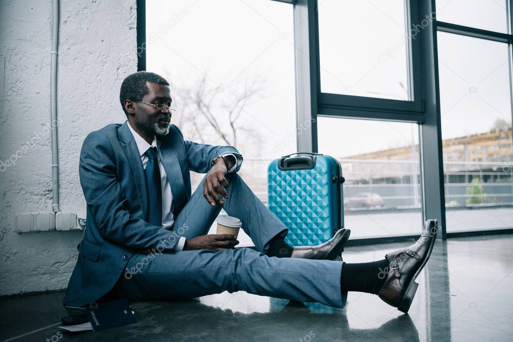 businessman sitting on floor at airport