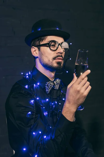 Man with champagne and christmas lights — Free Stock Photo