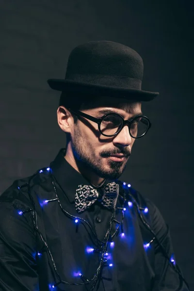 Homme à la mode avec des lumières de Noël — Photo gratuite