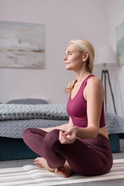 Vrouw die thuis yoga beoefent — Stockfoto