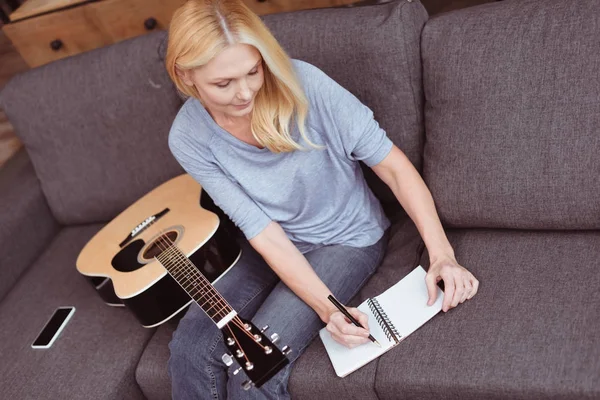 Frau mittleren Alters mit Gitarre zu Hause — Stockfoto
