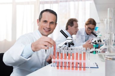 Test tüpü tutan bilimadamı