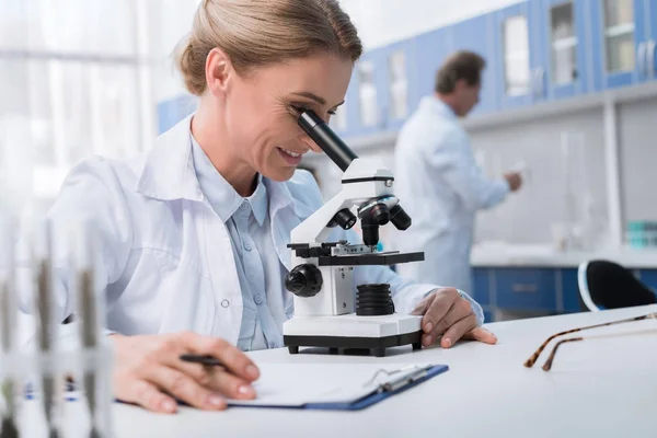 Chemist working with microscope — Stock Photo, Image