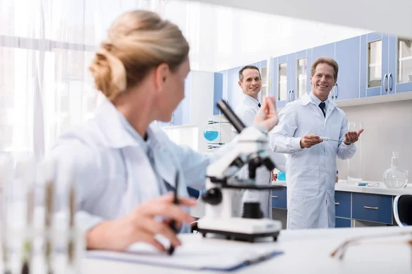 Científicos examinando tubo de ensayo — Foto de Stock