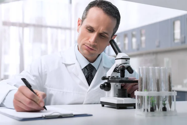 Lab technician taking notes — Stock Photo, Image