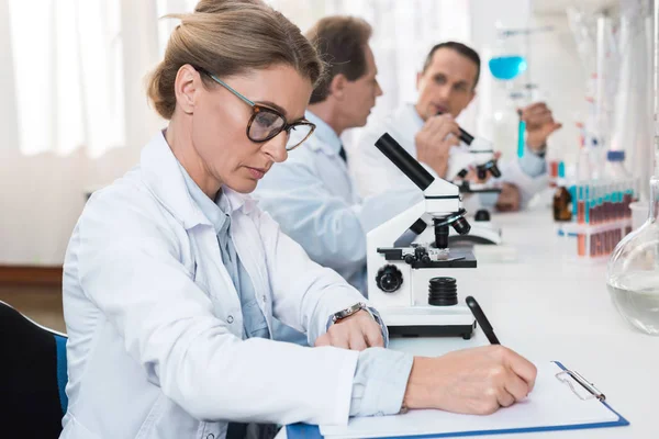 Lab technician taking notes — Stock Photo, Image